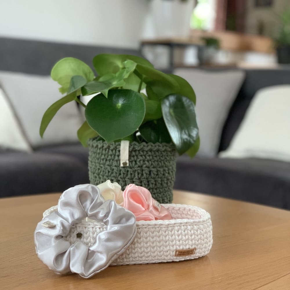 MaindorA-Boutique Artisanale en Ligne propose ici des accessoires faits main comme des chouchous pour les cheveux, des cotons lavables tout doux et bien d'autres trésors confectionné avec passion. Dans cette image des chouchous cousus à la main sont dans une panière tressée en corde de coton dans l'atelier MaindorA ainsi qu'un cache-pot tressé avec une plante verte dedans.