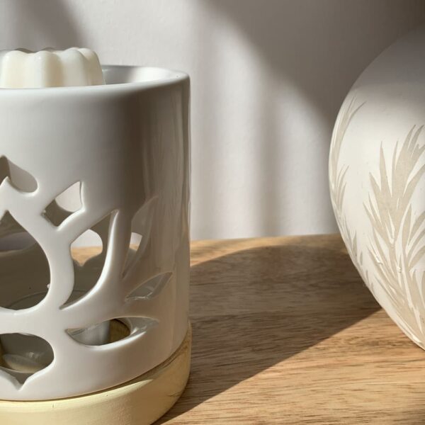 MaindorA-Coffret Fondants Parfumés RENAISSANCE : ici le brûle-parfum est présenté en tras gros plan. On distingue ainsi le motif de fleur de lotus ajouré pour laisser passer la lumière de la bougie.