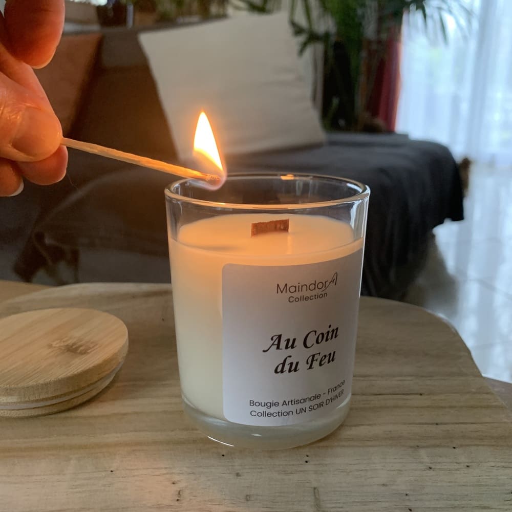 MaindorA-Bougie parfumée Au Coin du Feu – Collection UN SOIR D’HIVER, allumée avec sa mèche en bois dans une ambiance cocooning.
