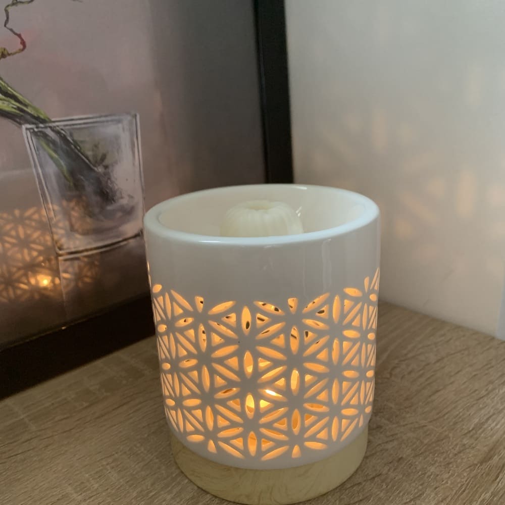 MaindorA-Coffret Fondants Parfumés RENAISSANCE : ici le brûle-parfum est présenté en tras gros plan. On distingue ainsi le motif de fleur de lotus ajouré pour laisser passer la lumière de la bougie.