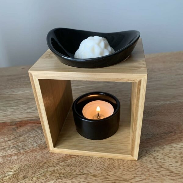 MaindorA-Coffret fondants parfumés ONYX avec brûle-parfum en bambou et céramique noire avec s bougie chauffe-plat allumée et le fondants ce cire dans sa coupelle.